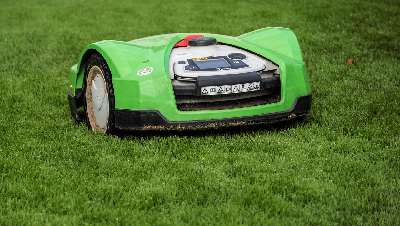 Slimme robotmaaier met zonnepaneel in zonovergoten tuin. Slimme robotmaaier met zonnepaneel in zonovergoten tuin.