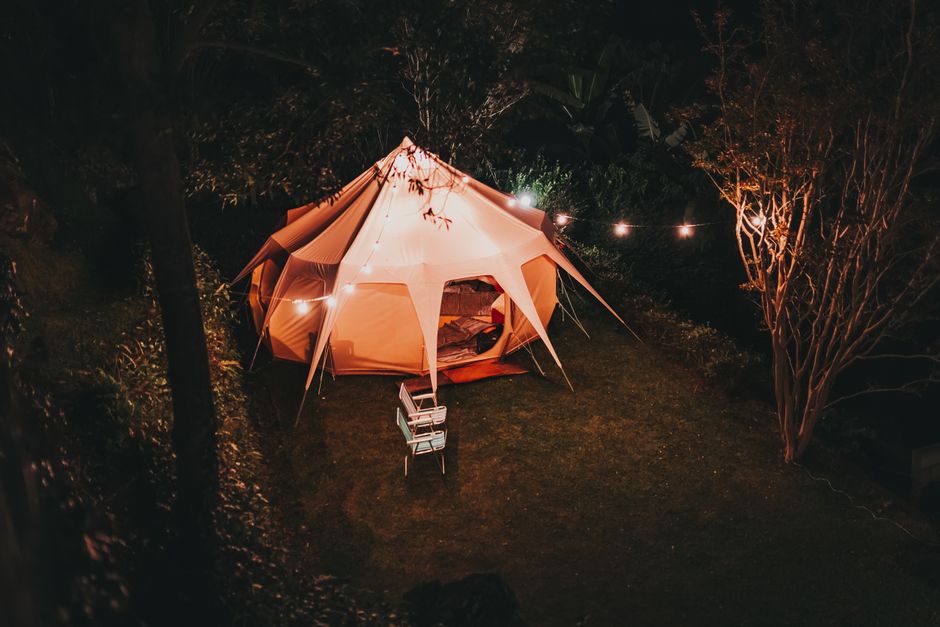 Stijlvolle kampeerstoelen naast opgemaakte tent. Stijlvolle kampeerstoelen naast opgemaakte tent.